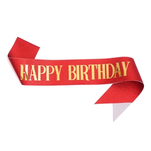 Close-up of red glitter birthday sash with gold Happy Birthday foil lettering