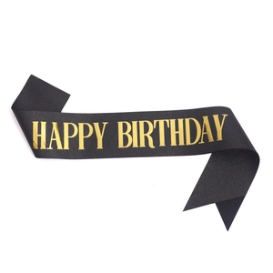 Detailed view of the black satin birthday sash with shining gold Happy Birthday lettering