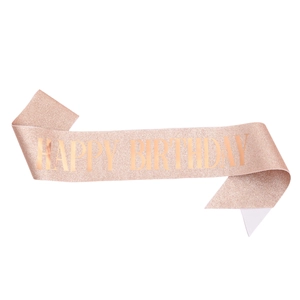 Macro view of rose gold glitter sash featuring the bold text HAPPY BIRTHDAY for party