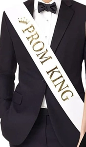 Detail of white satin Prom King sash featuring metallic gold foil lettering and crown