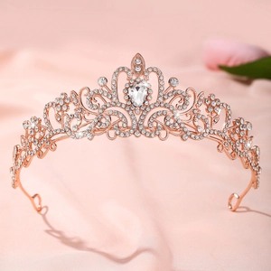 Détail d'une couronne de mariée or rose avec strass blancs sur fond de satin rose
