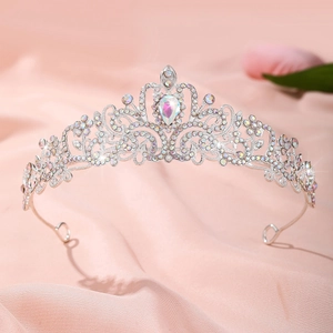 Détail d'une couronne en alliage argenté avec strass sur tissu en soie rose doux