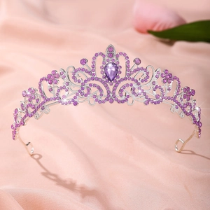 Détail de la couronne de mariée argentée avec strass violets sur soie rose
