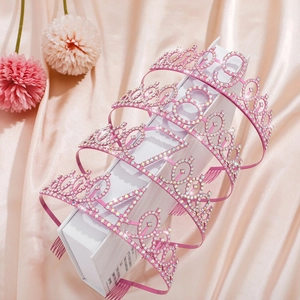Pink rhinestone birthday crowns set with numbers 18, 21, 30, 40 on silk floral background