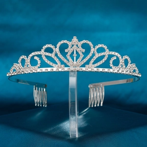 Détail d'un diadème en strass argenté avec motifs de cœur et peignes sur tissu bleu