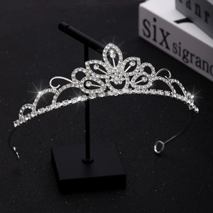 Elegant silver tiara with sparkling crystal hearts and floral patterns on display stand