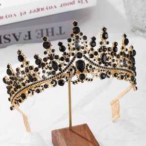 Detail view of a vintage gold alloy crown with elegant black crystals on a marble surface