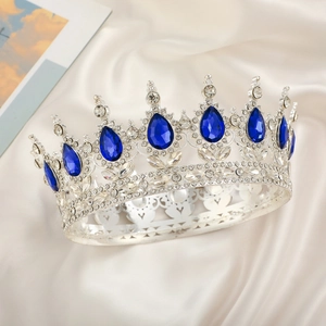 Close-up of silver bridal crown with drop-shaped blue rhinestones on satin fabric