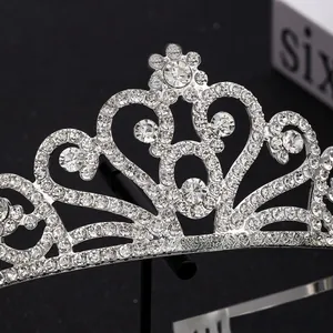 Detailed view of silver heart crown tiara with sparkling crystals and scrollwork