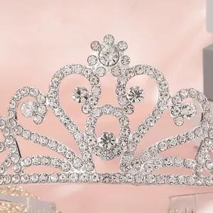 Detailed close-up of a silver tiara crown featuring heart-shaped crystal patterns and rhinestones