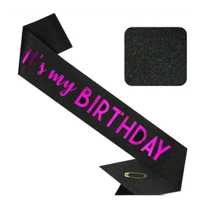 Détail d'écharpe noire scintillante avec texte It's my Birthday rose et épingle dorée