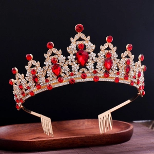 Nahaufnahme der goldenen Tiara mit Rubinstraßsteinen und Haarkämmen auf Holz