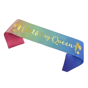 Close-up of iridescent rainbow birthday queen sash with golden foil lettering and mermaid