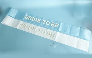 Detail of satin Bride To Be sash set with pearl lettering and silver safety pins