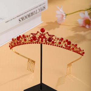 Macro detail of luxury gold bridal tiara with red pear-cut rhinestones and crystal accents