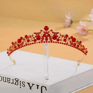 Luxury alloy bridal crown with red rhinestones and golden base on a vintage book