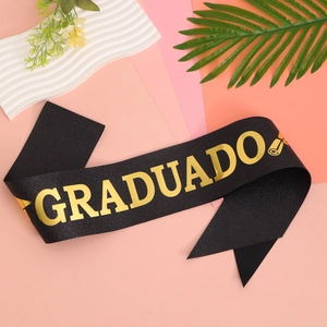 Close-up of black glitter graduation sash with gold GRADUADO text and mortarboard icon