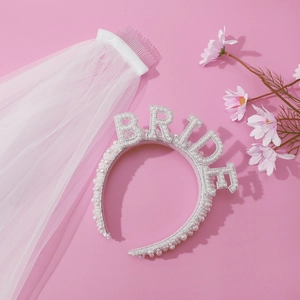 Detail of elegant white pearl BRIDE headband and wedding veil on pink background