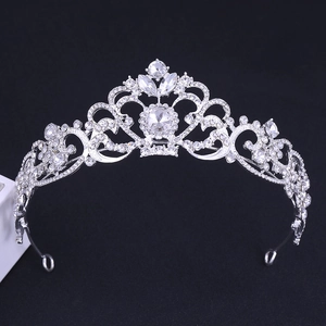 Detailed view of silver bridal tiara with sparkling rhinestones on blue background