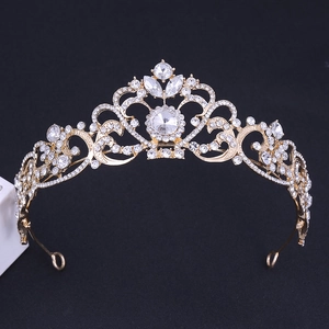 Close-up of golden bridal crown featuring intricate metalwork and clear crystal rhinestones