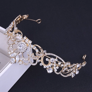 Macro detail of golden bridal crown with sparkling white rhinestones and baroque patterns