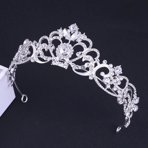 Detail view of ornate silver bridal crown with sparkling rhinestones on dark background