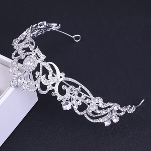 Detailed view of silver crystal tiara featuring intricate scrolls and teardrop rhinestones