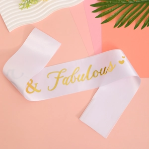 Close-up of white satin sash with gold foil Fabulous text and heart detail for party