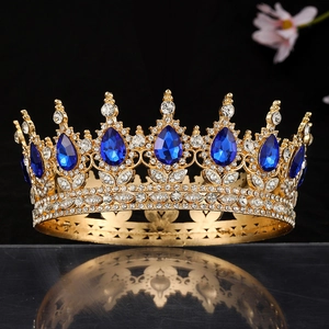Detail of a gold baroque crown with large royal blue teardrop gems and white crystals