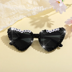 Detail of heart-shaped sunglasses with black rhinestones and Birthday Queen beads