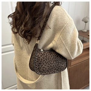 Detailed back view of a leopard print baguette bag worn by a model in a minimal setting