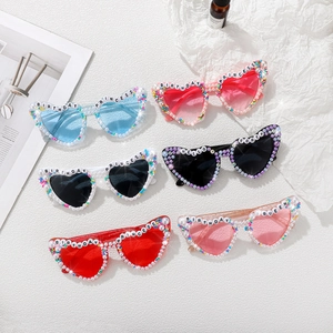 Flat lay of heart-shaped sunglasses with pearl trim and BIRTHDAY QUEEN letter beads