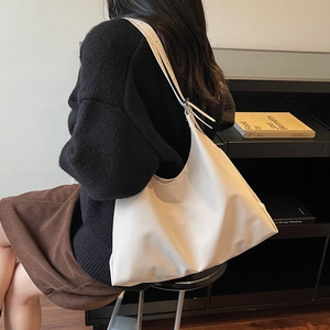 Borsa tote minimalista in pelle bianca da donna mostrata in una vista laterale a spalla