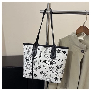 Detail of the white tote bag featuring black street-style graffiti and doodle prints