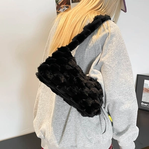 Large black plush tote bag with woven texture worn by model for casual autumn winter look