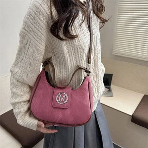 Fashionable rose pink crescent shoulder bag with silver M logo and brown straps