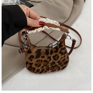Close-up of leopard print mini handbag with white lace trim and silver zipper detail