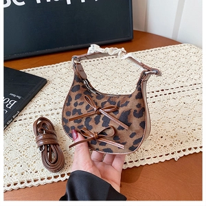 Detail of leopard print crescent mini bag with leather bows and lace strap accent