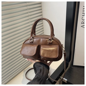 Gros plan du sac à main marron café brillant avec doubles poches et détails dorés