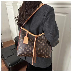 Detail of vintage monogram tote bag with brown leather straps and metal base studs