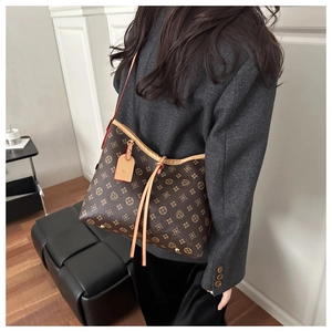 Detail of vintage monogram pattern on tote bag with leather trim and drawstring