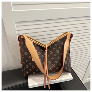 Detail of classic brown monogram bucket bag with leather strap and drawstring closure