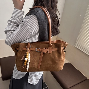 Vintage brown suede tote bag with beaded pendant and metal buckle detail on shoulder