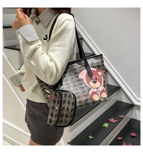 Detail of grey monogram tote bag with cartoon bear and matching mini coin purse