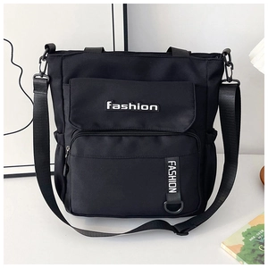 Detailed front view of a black canvas tote bag showing large capacity and adjustable strap