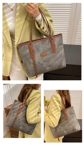 Detail of grey marble pattern tote bag with brown leather straps and fashion logo