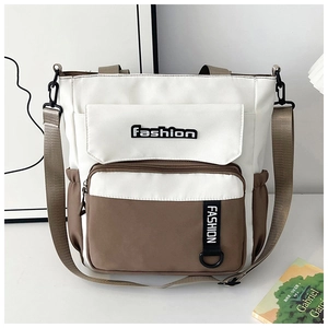 Detail view of canvas crossbody bag showing contrast panels and multi-pocket storage design