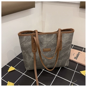 Detail of vintage canvas tote bag with brown leather trim and fashion brand tag