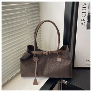 Detail of retro leopard print tote bag with soft suede texture and leather strap buckle
