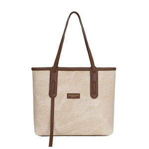 Minimalist beige canvas tote bag with brown leather trim and fashion logo detail